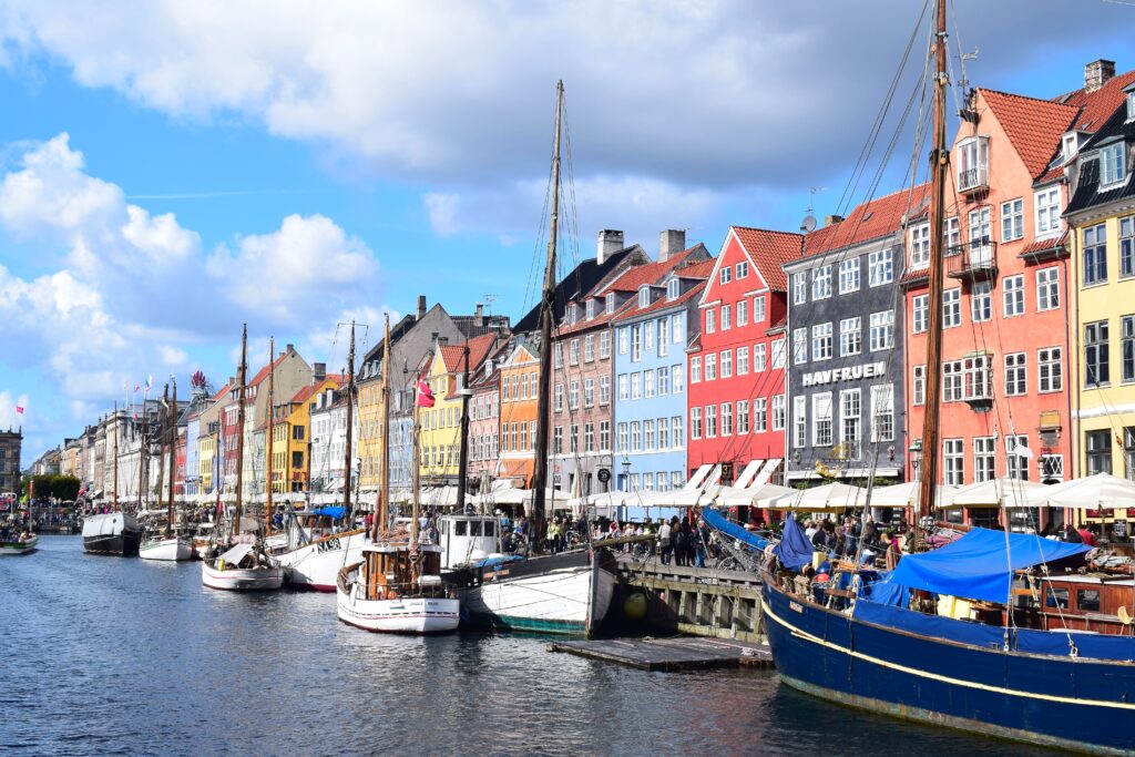 Kopenhagen bei strahlendem Sonnenschein, bunte Häuser am Wasser an der Promenade 