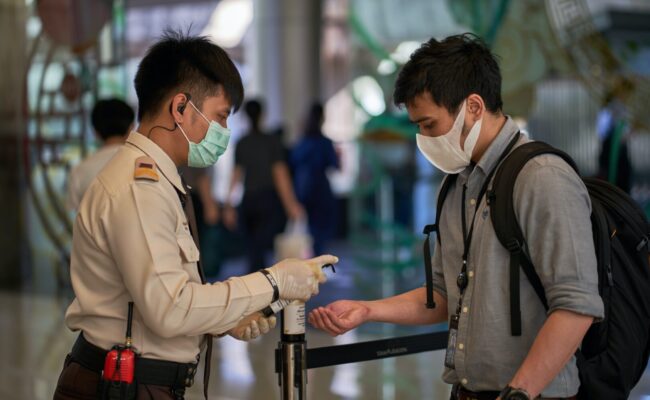 Mann steht in Bangkok an der Einreisekontrolle am Flughafen