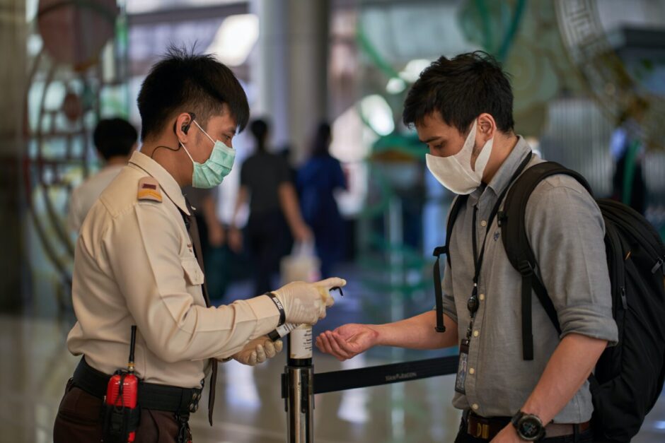 Mann steht in Bangkok an der Einreisekontrolle am Flughafen