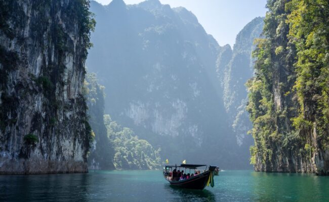 Longtailboot im Wasser zwischen Steilklippen in Thailand